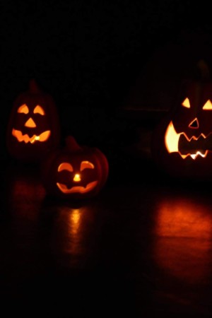 illustration du spectacle d'halloween représentant des bougies en forme de citrouilles allumées dans le noir