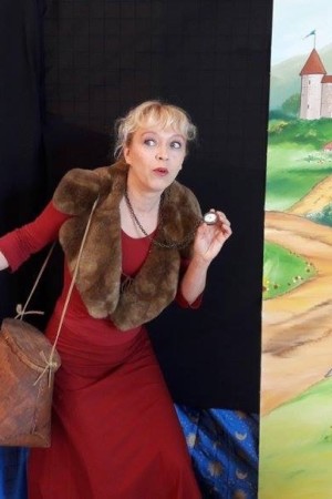 conteuse évoluant devant des illustrations de spectacles de contes