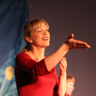 conteuse racontant le spectacle en tendant la main vers le public