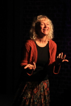 La conteuse Emmanuelle Gryson interprétant un conte sur la scène d'un théâtre