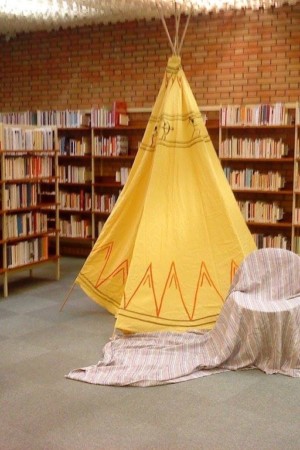 tipi indien entouré de livres dans une bibliothèque